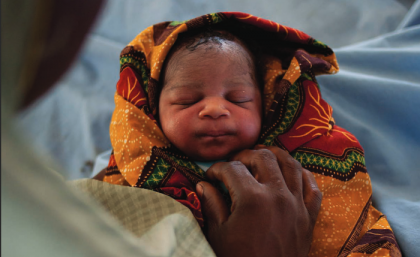 Newborn baby wrapped in colourful cloth